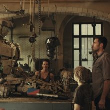 Evangeline Lilly e Hugh Jackman ridanno vita a un robot in una scena di Real Steel con Dakota Goyo