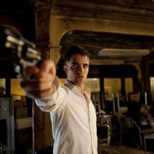 Robert Pattinson e la sua pistola in una drammatica immagine di Cosmopolis