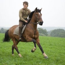 Jeremy Irvine a cavallo del suo amico Joey in una scena del film War Horse