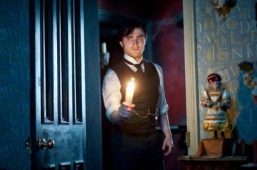 Daniel Radcliffe si aggira per la casa con una candela in una scena del thriller The Woman in Black