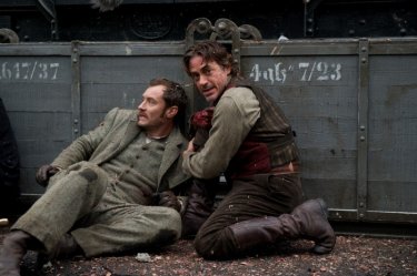 Jude Law e Robert Downey Jr. cercano di ripararsi dal pericolo in una scena di Sherlock Holmes: Gioco di ombre