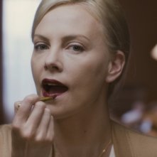 Charlize Theron si tinge le labbra in una scena del film Young Adult