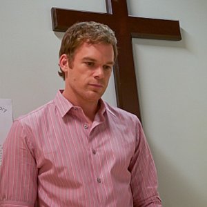 Michael C. Hall sotto un crocifisso in una scena dell'episodio Sins of Omission
