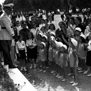 Il sorriso del capo: Benito Mussolini in un'immagine d'archivio circondato da un gruppo di bambini