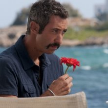 Paolo Kessisoglu annusa un fiore rosso in una scena di Immaturi - Il viaggio