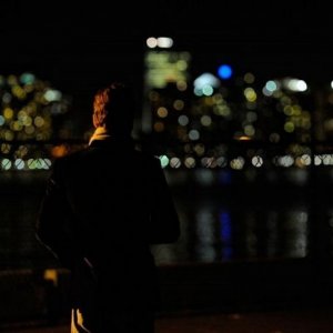 Michael Fassbender di spalle verso lo skyline notturno in un'immagine di Shame