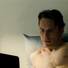Shame: Michael Fassbender a letto con il suo computer in una scena del film