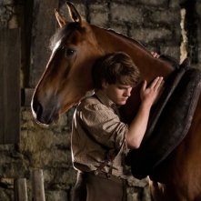 Jeremy Irvine abbraccia il suo cavallo in una scena di War Horse