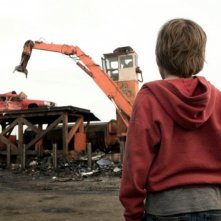 Hesher è stato qui: Devin Brochu di spalle assiste alla demolizione di un'auto in una scena del film