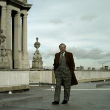 Toby Jones in una scena del film La talpa passeggia su uno dei ponti di Londra