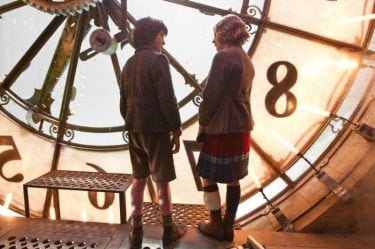 Asa Butterfield e Chloe Moretz dietro un orologio gigante in una scena di Hugo Cabret 3D