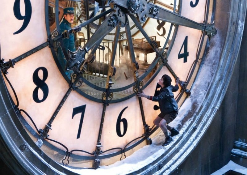 Asa Butterfield si nasconde da Sacha Baron Cohen in una scena di Hugo Cabret 3D