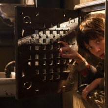 Hugo Cabret 3D: Asa Butterfield fa capolino da un passaggio segreto in una scena del film
