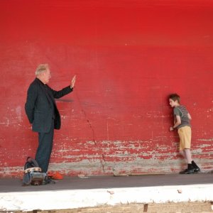 Thomas Horn e Max von Sydow sullo sfondo di una parete rossa in Molto forte, incredibilmente vicino