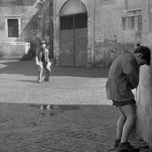 Ladri di biciclette: Enzo Staiola con Lamberto Maggiorani (sullo sfondo) in una scena del film