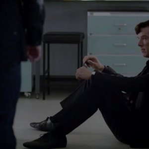 Benedict Cumberbatch seduto sul pavimento del laboratorio mentre Martin Freeman lo osserva in The Reichembach Fall
