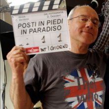 Carlo Verdone sul set di Posti in piedi in Paradiso mostra con orgoglio il ciak
