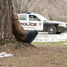 Daniel Craig rannicchiato sotto un albero in un'immagine di Dream House