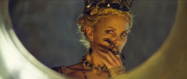 Charlize Theron si osserva nello specchio magico in una scena de Biancaneve e il cacciatore