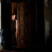 Daniel Radcliffe sospettoso alla porta in una scena del film The Woman in Black