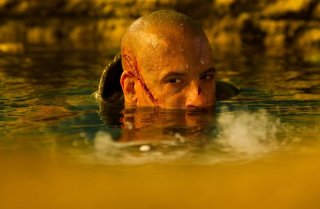 Vin Diesel immerso nell'acqua in una scena di Riddick