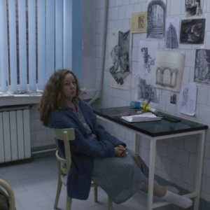 Suzan Crowley insieme ai suoi inquietanti disegni in una scena de L'altra faccia del diavolo