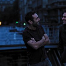 Jean Dujardin e Gilles Lellouche sorridono in una scena de Gli infedeli