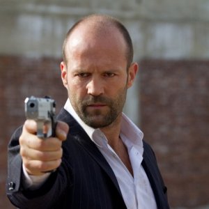 Jason Statham, nei panni di Luke Wright, spiana la sua pistola in Safe