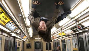 Andrew Garfield cammina a testa in giu sul tetto di un autobus in una scena The Amazing Spider-Man