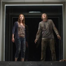 Quella casa nel bosco: Fran Kranz e Kristen Connolly sul monitor di una telecamera che li osserva in una scena del film