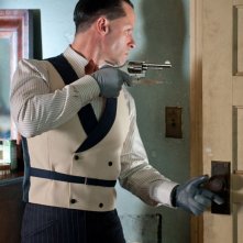 Guy Pearce spia pistola in pugno i suoi nemici in una scena di Lawless