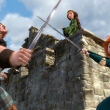 Merida incrocia la spada col padre sotto lo sguardo preoccupato della madre in una scena di Ribelle - The Brave