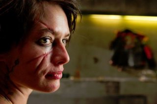 Lena Headey col volto sfigurato in una scena di Dredd