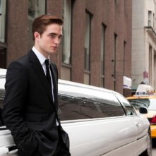 Cosmopolis: Robert Pattinson in una scena del film poggiato su una lunghissima limousine