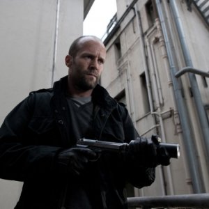 Killer Elite: Jason Statham con la sua arma letale in una scena del film