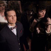 Tobey Maguire circondato dagli avventori del locale cuore degli anni ruggenti in una scena di The Great Gatsby
