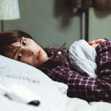 Babycall: Noomi Rapace sdraiata in un letto in una scena del film