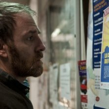 Gli equilibristi: Valerio Mastandrea legge annunci su una bacheca in una scena del film