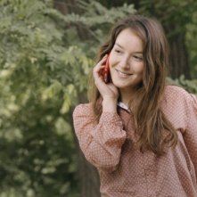 Anaïs Demoustier sorride e parla al telefono in una scena di Elles