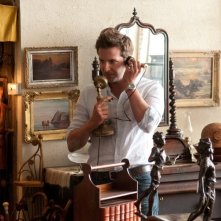 Bradley Cooper alle prese con un vecchio telefono d'antiquariato in una scena di The Words