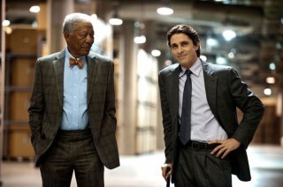 Christian Bale e Morgan Freeman sorridono compiaciuti in una scena di Il cavaliere oscuro - Il ritorno