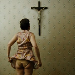 Paradise: Faith, la protagonista del film Maria Hofstätter di spalle guarda un crocefisso in una scena del film