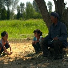 Fly with the Crane: l'anziano Ma Xingehun in una scena del film con alcuni bambini