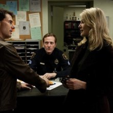 Tom Cruise e Rosamund Pike di fronte a un poliziotto in una scena di Jack Reacher - La prova decisiva