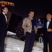 Sanremo 1984: Eros Ramazzotti vince la sezione nuove proposte con Terra promessa. Accanto a lui Pippo Baudo