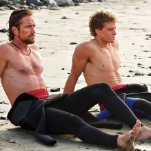Gerard Butler e Jonny Weston seduti sulla sabbia in Chasing Mavericks