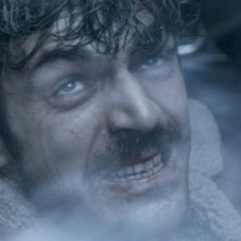 Il cecchino: un primo piano sofferente di Luca Argentero, ferito in una scena del film