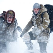 Liam Neeson in fuga dai lupi insieme ai suoi compagni in una scena di The Grey