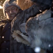 Liam Neeson lotta con un lupo in una scena action di The Grey