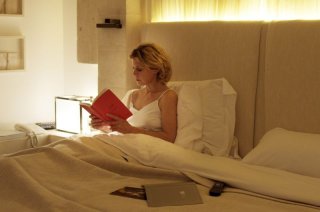 Viaggio sola: Margherita Buy legge un libro prima di dormire in una scena del film